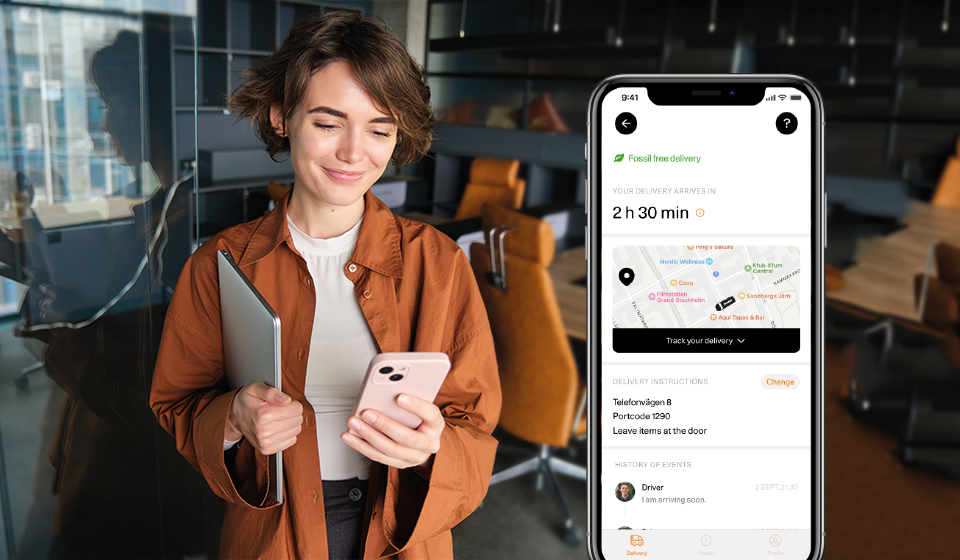 Woman using a smartphone with an Airmee app displayed, standing in an office setting.