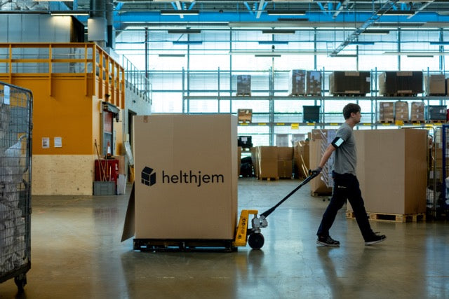 Helthjem box moved in a warehouse by a warehouse worker